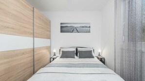 A modern bedroom with a bed, bedside tables, and a framed picture on the wall. - 3 BD Villa with Private pool, Jacuzzi and Volleyball Court (Umag)
