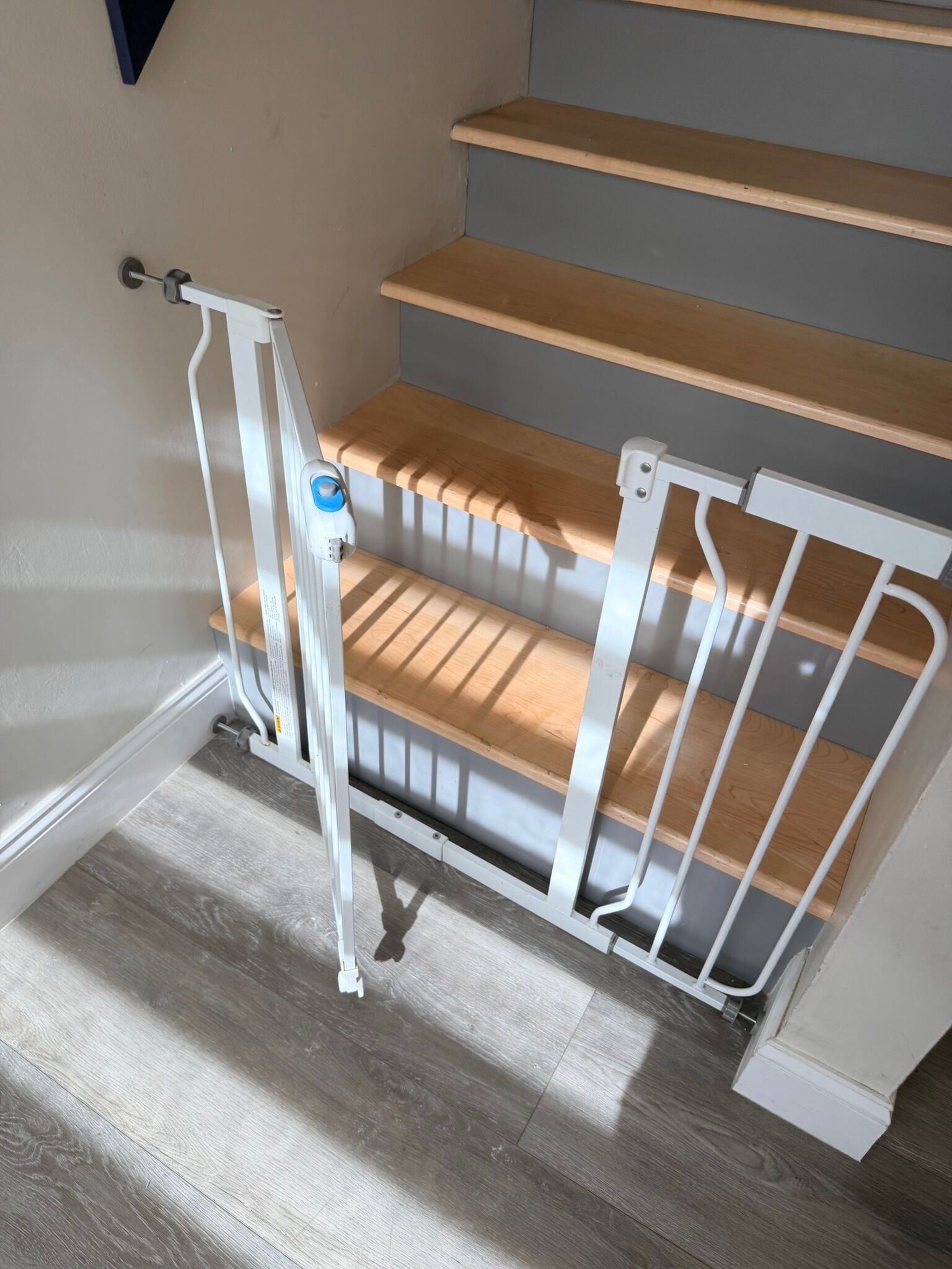 A staircase with wooden steps and a white metal railing.