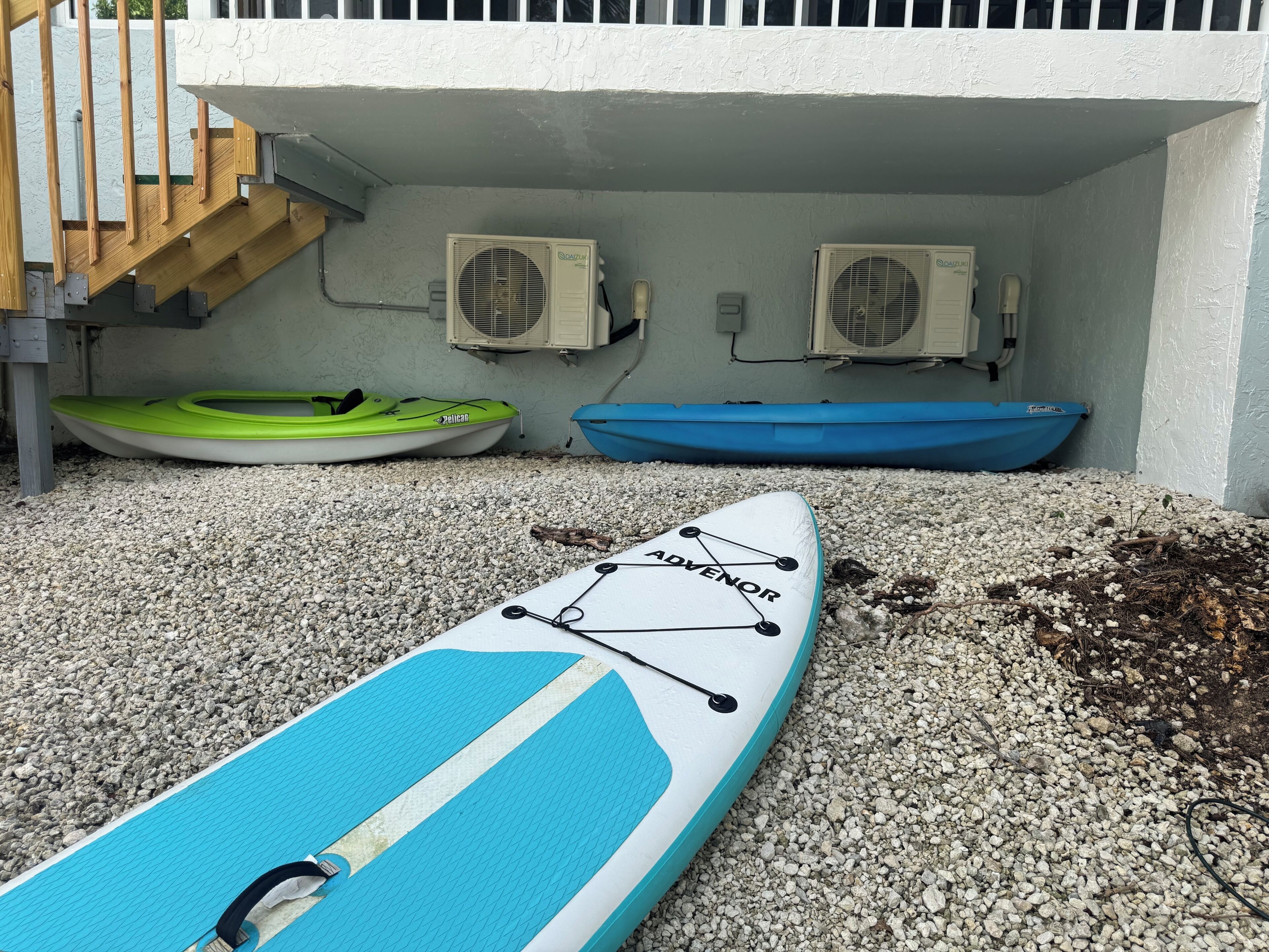 Un kayak sur lequel est inscrit le mot « ADVENOR », deux bateaux et deux unités de climatisation fixées au mur.
