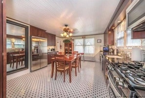Enjoy meals together at the large dining table surrounded by comfortable chairs in this well-equipped kitchen.