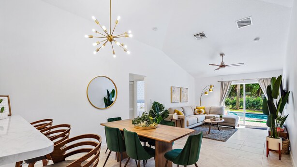 A modern living room with a dining area, a ceiling fan, and a view of a swimming pool. - *NEW 3/2 Pool Home, Private Yard, Great Location! (Jupiter)