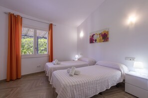 A room with two beds, a nightstand, a lamp, and a window with curtains. - Villa with 3 bedrooms, 2 bathrooms, large terrace with pool and barbecue (Crestatx)