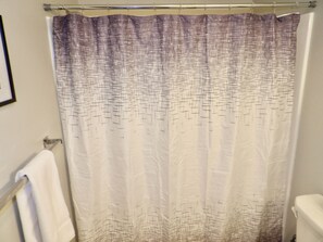 Tina con regadera, toallas, jabón, papel de baño 