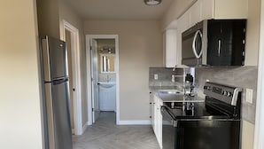 Una cocina moderna con refrigerador, estufa, microondas y pileta.