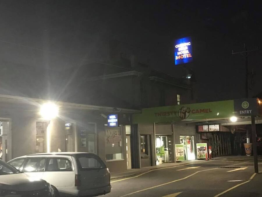 Un motel avec une enseigne indiquant « Camel Inn » et une autre indiquant « Thirsty Camel ».