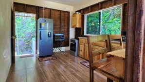 Une cuisine spacieuse dotée de meubles en bois, d’un réfrigérateur et d’un coin repas avec une table et des chaises en bois.