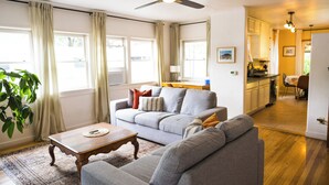 A living room with a grey sofa, a wooden coffee table, and a ceiling fan.