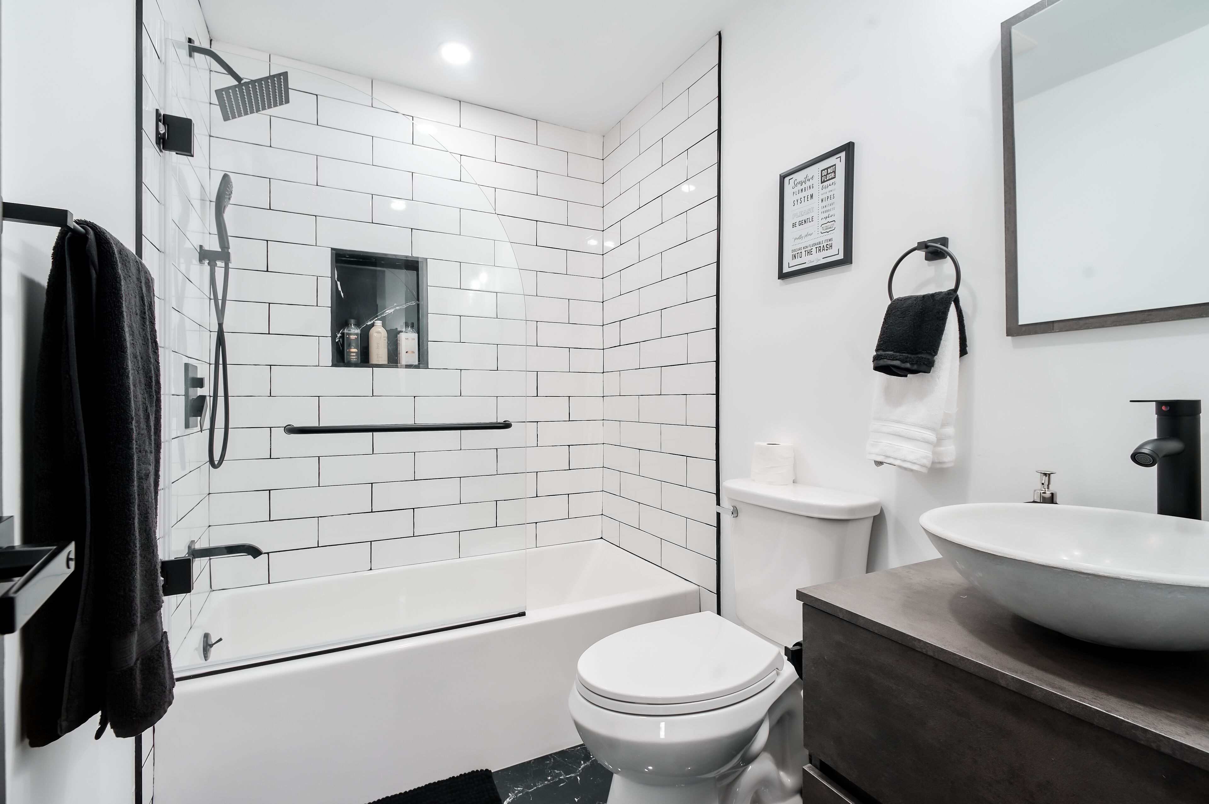 Een moderne badkamer met een bad, toilet en wastafel.
