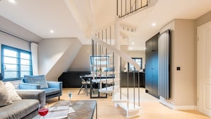 Un appartement moderne de style « loft » comprenant un coin repas, une cuisine et un espace de vie.