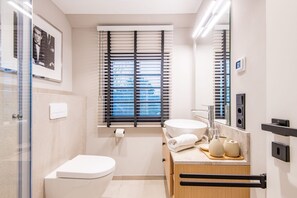 A modern bathroom with a toilet, sink, and shower. - Modern. Gemütlich. Zentral. - Objekt-id: Ilw/03 - Inselliebe Westerland (Sylt)