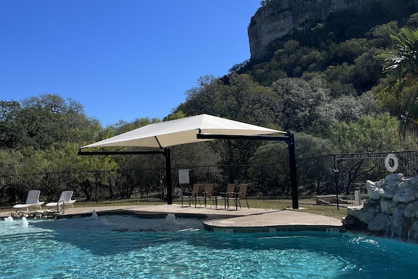 Alberca al aire libre, sombrillas en la alberca y camastros