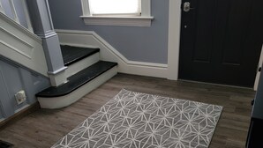 Un escalier avec des moulures blanches et des marches noires menant à une porte sombre.