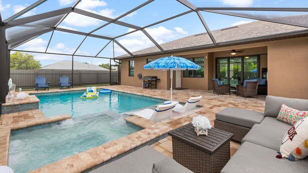 A covered outdoor swimming pool with lounge chairs and a patio area.