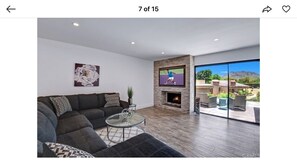 A modern living room with a sofa, coffee table, and fireplace. - Contemporary home in gated palm desert community (Palm Desert)