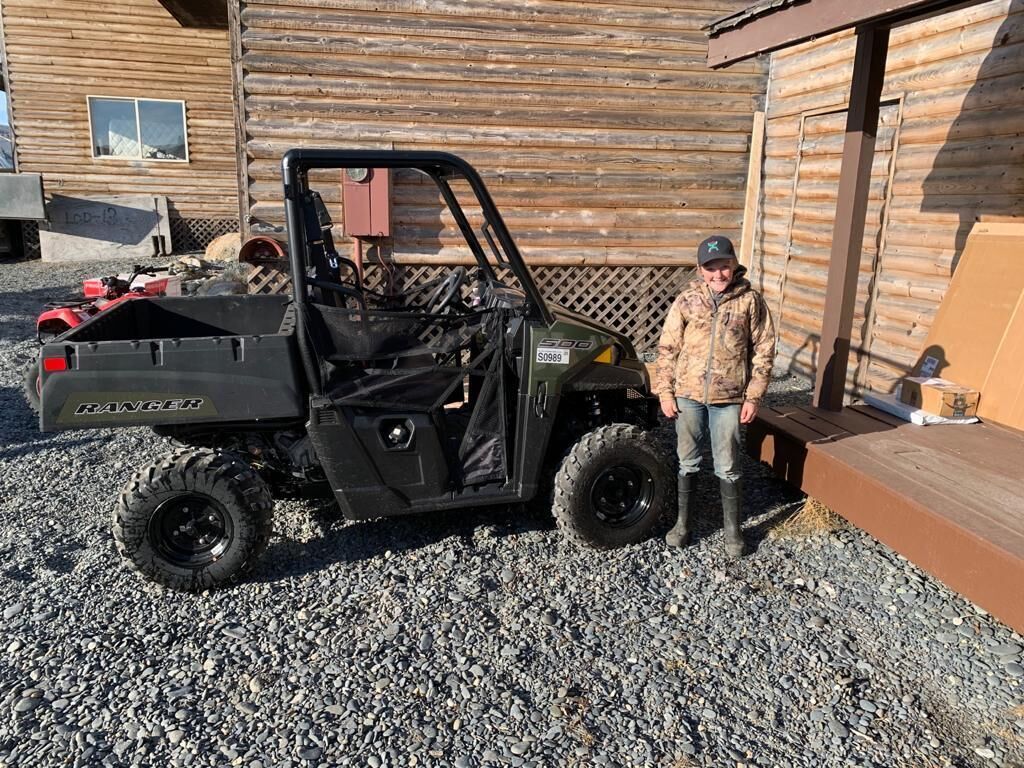 A black utility vehicle labeled "RANGER" parked on gravel.