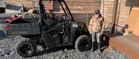 A black utility vehicle labeled "RANGER" parked on gravel.