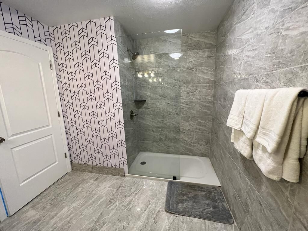 Un bagno con doccia, vasca e porta.