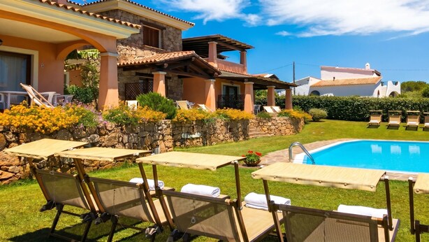 Un espace aménagé au bord de la piscine, avec des chaises longues et une piscine.