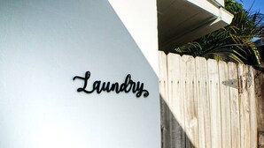 A white wall with a black sign that reads "Laundry." - Poinsettia Paradise - 2 BDR Wing Near Beach (Fort Lauderdale)
