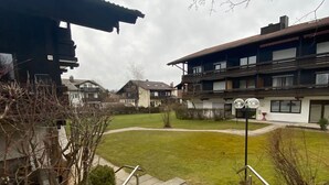 A courtyard with a grassy area, a staircase, and buildings with balconies and windows. - Vacation apartment Leo, 65 sqm 1st floor, 2 bedrooms (Bad Endorf)