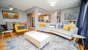 A modern living room with a white sofa, yellow armchair, and a white coffee table. - Cozy 3 Bedroom Contemporary Home With Free Parking  (Edmonton)