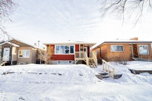 A row of residential buildings with a snow-covered ground. - Cozy 3 Bedroom Contemporary Home With Free Parking  (Edmonton)