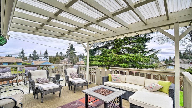 Un patio cubierto con mobiliario exterior, incluyendo un sofá, sillas y una mesa de centro.