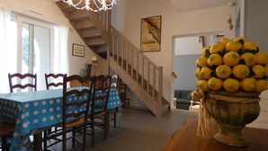 A dining area with a wooden staircase, a chandelier, and a table with chairs.