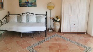 A bedroom with a bed, a painting, a lamp, a wardrobe, and a tiled floor. - Constance mountain view with winter garden (Oberstaufen)