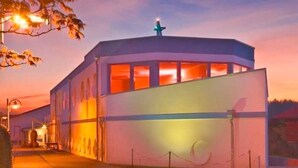 A modern building with a flat roof and a large, illuminated entrance. - Apartment handicapped accessible (balcony or terrace) - Hanse-Kogge Hotel & (Koserow)