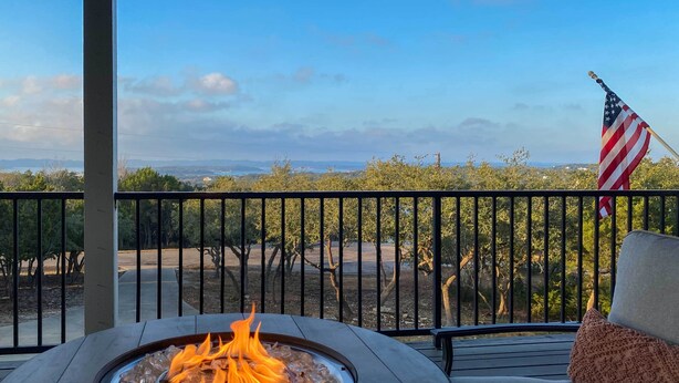 A balcony with a fire pit, an American flag, and a view of a vineyard. - Luxe Canyon Lake Home w/ Gorgeous Lake Views! (Canyon Lake)