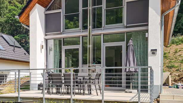 A two-story building with large windows, a balcony with outdoor seating, and a visible address sign. - Cozy home in Lautenthal with sauna (Lautenthal)