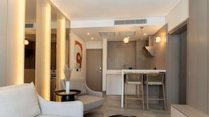 A modern living room with a sofa, a coffee table, and a dining area with a table and chairs. - Bodrum Astrid Hotel  (Bodrum)