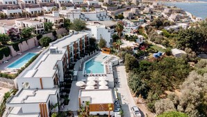A resort with multiple swimming pools, a central building with a pool, and a view of the sea. - Bodrum Astrid Hotel  (Bodrum)