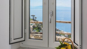 A room with a view of the sea through a door. A basket with lemons is visible on the windowsill. - Villa Salice with private hot tub and solarium (Amalfi)