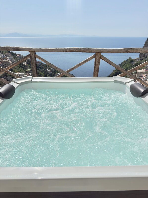 Un jacuzzi con vistas al mar y un paisaje montañoso.