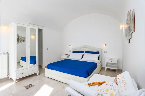 Un dormitorio con cama, armario y mesita de noche.