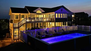Ein zweistöckiges Haus mit Balkon und Swimmingpool.