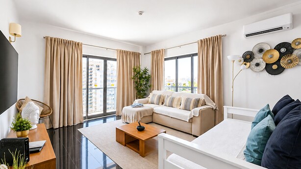 Una sala de estar moderna con un sofá, una mesa de centro y un televisor.