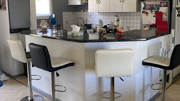 A modern kitchen with a central island, bar stools, and a refrigerator with photos. - Rooms in house (Gercourt-et-Drillancourt)