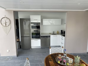 Eine moderne Küche mit weißen Schränken, einem eingebauten Backofen und einem Edelstahlkühlschrank.