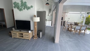 Un salon moderne doté d’un téléviseur à écran plat, d’une table basse en bois et d’un mur végétal décoratif.