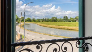 A view of a river from a window with a metal railing. - Apartment for 2 people surrounded by greenery! (Mira)