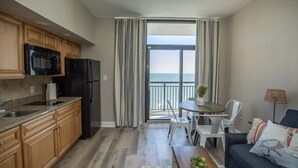 Un espacio habitable compacto con cocina, comedor y balcón con vistas.