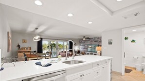 A modern kitchen with a large island, stainless steel appliances, and a view to the outdoor patio.