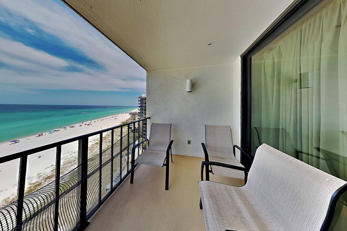 A balcony with a view of the beach and ocean.