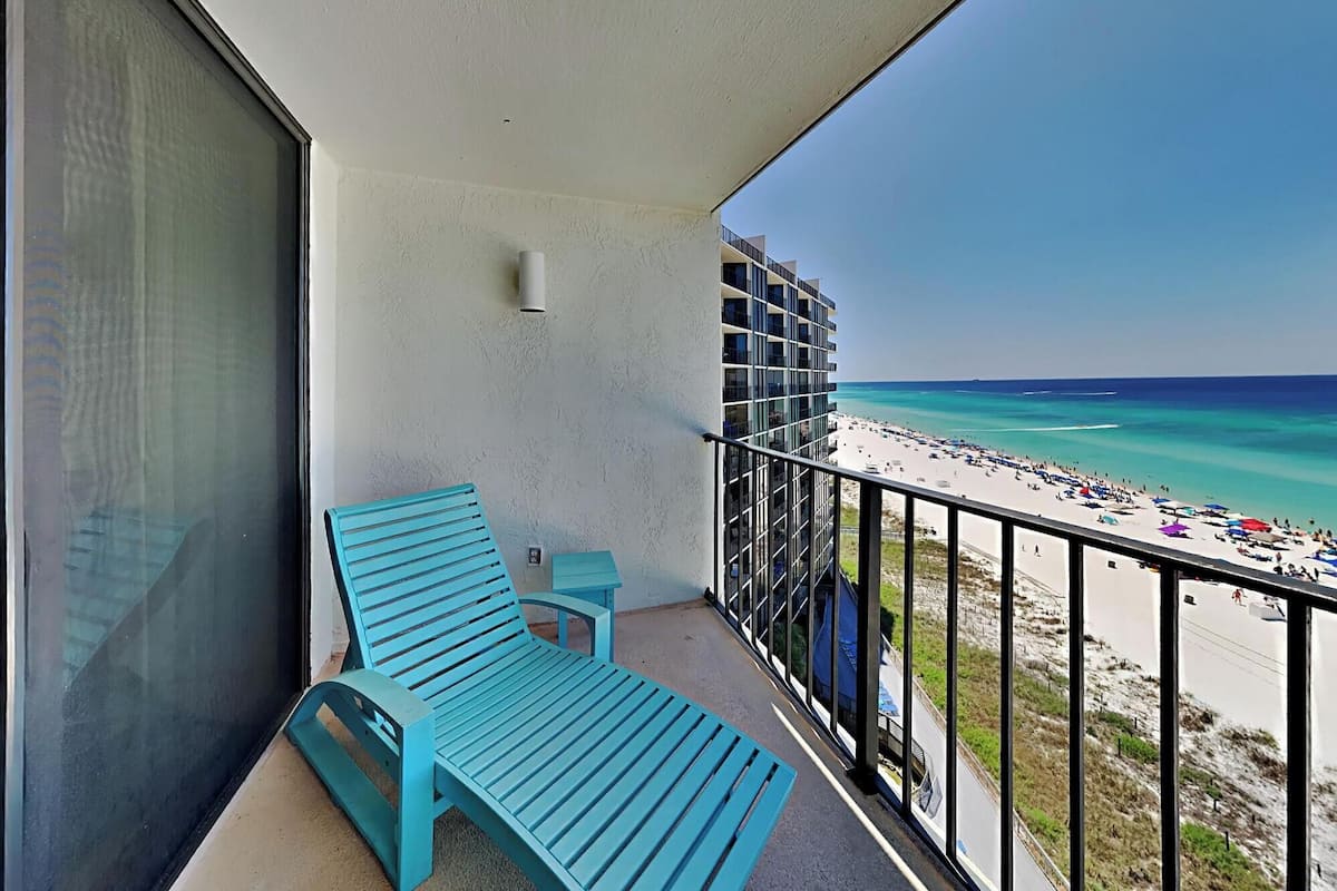 A balcony with a view of a beach and ocean.