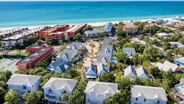 An aerial view of a coastal residential area with houses, a beach, and a hotel with a red roof. - AMI Moana Villa 3-minute walk to the beach plus heated pool, grill, beach gear (Holmes Beach)