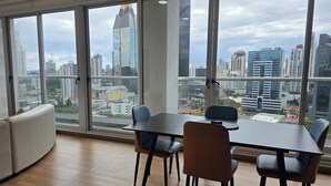 Een moderne kantoorruimte met een groot raam, een tafel en vier stoelen.