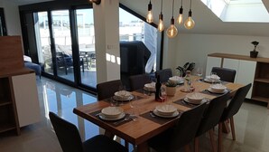 Un comedor moderno con una mesa de madera dispuesta para seis personas, rodeada de sillas negras.